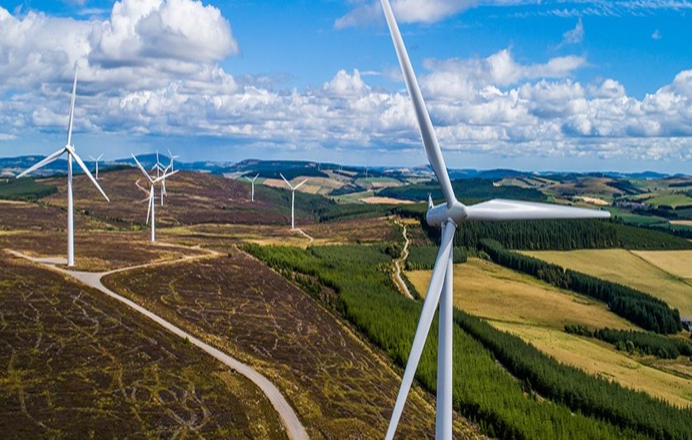 在绿地、蓝天交相辉映的乡村地区，9台风力涡轮机正在运转工作。